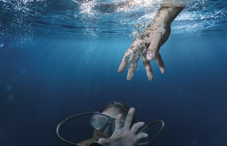 scuba diver reaching out to hand